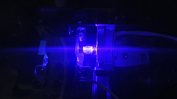 Das Bild zeigt eine Fotografie eines Laserstrahlverlaufs durch ein Volumenholografisches Bragg-Gitter.