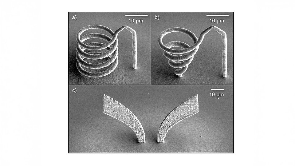 SEM images of 3D-printed microstructures: (a and b) helical antennas and (c) a Vivaldi antenna. Each image includes a scale bar indicating 10 µm.