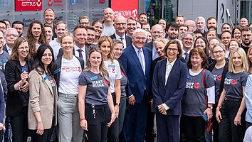 Das Bild zeigt ein Gruppenfoto des Bundespräsidenten Frank-Walter Steinmeier, des Ministerpräsidenten Dietmar Woidke und der Präsidentin der Brandenburgischen Technischen Universität Cottbus-Senftenberg (BTU) Gesine Grande mit den Beteiligten der Veranstaltung.