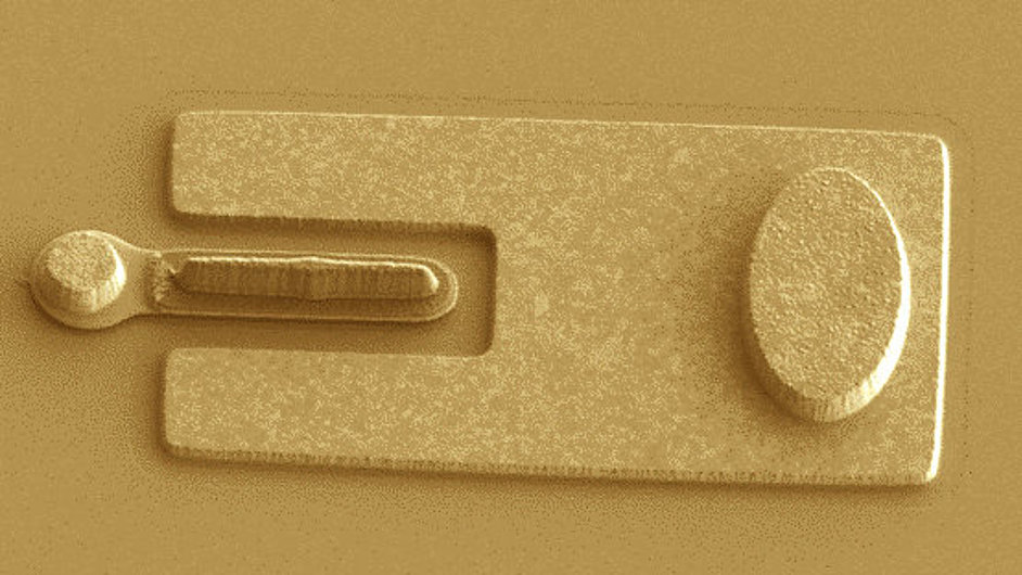 A close-up of a transistor featuring a metallic rectangular structure with a U-shaped cutout and an oval element, showcasing its microfabricated design.